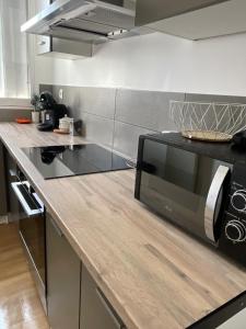 a kitchen with a counter top with a microwave at Le Repaire Urbain - 8 voyageurs in Orléans
