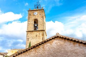 普朗德拉图尔Superbe appartement neuf, climatisé centre village的一座建筑物顶部有钟的塔楼