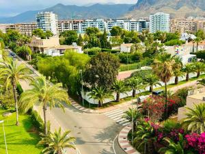 a city street with palm trees and buildings and mountains at TrendyHomes Aguadulce Bay II in Aguadulce