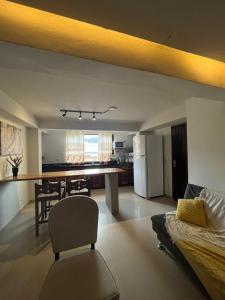 Una sala de estar y una cocina con un sofá y una mesa. en 02 Lindo apartamento da pedra com churrasqueira, en São Sebastião