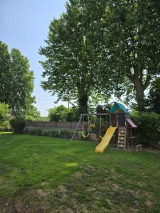 a playground with a slide in a yard at Partie privative dans villa 6 personnes piscine climatisé in Les Arcs sur Argens