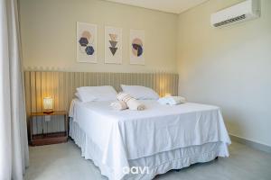 una camera da letto con un letto bianco con asciugamani sopra di Flat Ile de Pipa Sicilia by Qavi a Pipa