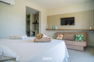 una camera da letto con un grande letto bianco e un divano di Flat Ile de Pipa Sicilia by Qavi a Pipa Altre 6 foto
