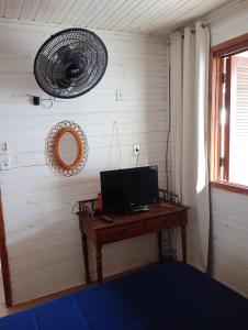 ウルグアイアナにあるCasa aconcheganteのデスク、テレビ、ファンが備わる客室です。