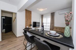 a kitchen and living room with a table and chairs at Apartmani Kornelija in Kaštela
