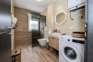 a bathroom with a washing machine and a sink at Apartmani Kornelija in Kaštela +98 photos