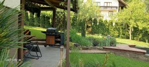 a patio with a grill in a garden at Apartament Kapi in Kalwaria Zebrzydowska