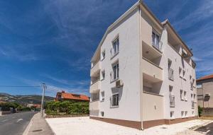 a large white building on the side of a street at Apartmani Kornelija in Kaštela