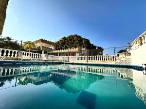 a swimming pool with a white fence and blue water at SGH Castillo Aqua in Santa Marta