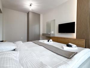 a bedroom with a large white bed with a flat screen tv at Airport Nest Private Parking, AC and Smart TV in Cluj-Napoca