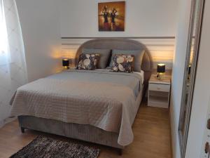 a bedroom with a large bed and two night stands at Apartments Lea with pool in Malinska