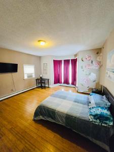 a bedroom with a large bed and a flat screen tv at Spacious one bedroom apartment near Whole Foods, Brown University 22F in Providence