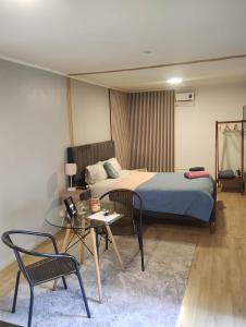 a bedroom with a bed and a table and chairs at Beehouse Casa Miel Villa Alemana in Villa Alemana