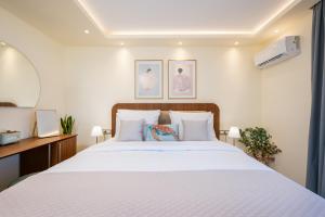 a bedroom with a large bed with white sheets at Diamante Del Mar Thalia and Erato in Kos