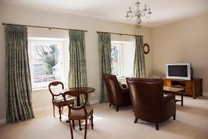 a living room with chairs and a table and a television at Ballinclea House Bed and Breakfast in Brittas Bay
