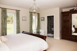 a bedroom with a bed and a large window at Ballinclea House Bed and Breakfast in Brittas Bay