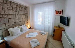 a bedroom with a large bed with two towels on it at Apartments Mitrovići Miločer in Sveti Stefan