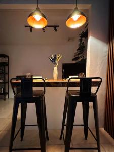 two chairs and a table in a room with two lights at The Lounge Titanium by KRD in Butuan +6 photos