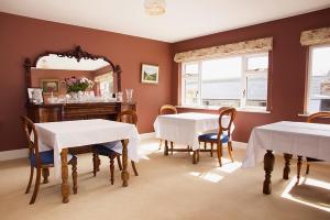 une salle à manger avec deux tables et un miroir dans l'établissement Ballinclea House Bed and Breakfast, à Brittas Bay