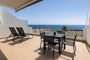 a patio with a table and chairs on a balcony at Arthouse Sea View - Acquamarina e Zaffiro in Puerto del Carmen