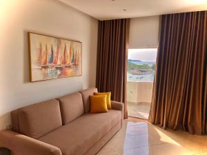 a living room with a couch and a large window at Dine Hotel in Ksamil