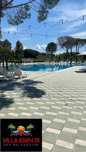 都拉斯Villa Eden 111, Perla Resort, Bay of Lalzi的一张带椅子和标志的游泳池的照片