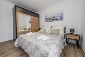 a bedroom with a bed with two towels on it at Apartmani Kornelija in Kaštela
