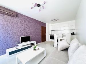 a living room with a purple wall at Park suite in Burgas