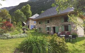 a stone house with a table and chairs in a yard at Chez Maria in Corbel