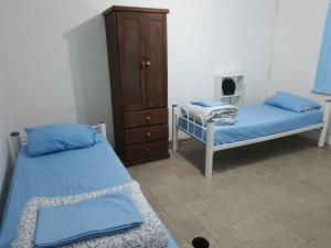 a room with two beds and a dresser in it at Hostel Downtown Las Morenas in Buenos Aires