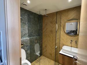 ネア・ムダニアにあるHasi Suites Two Bedroom Duplexのシャワー、トイレ、洗面台を備えたバスルーム +6枚の写真