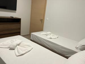 ネア・ムダニアにあるHasi Suites Two Bedroom Duplexのベッドルームにタオル付きのベッド2台が備わります。