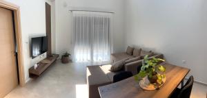 ネア・ムダニアにあるHasi Suites Two Bedroom Duplexのソファとテーブルのあるリビングルーム