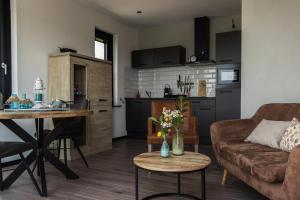 a living room with a couch and a table at The White House Apartment in Tholen