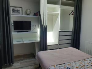 a bedroom with a tv and a bed in a room at L'Atelier in Auxerre