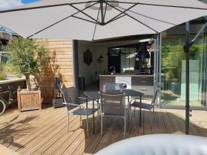 a patio with a table and chairs and an umbrella at L'Atelier in Auxerre