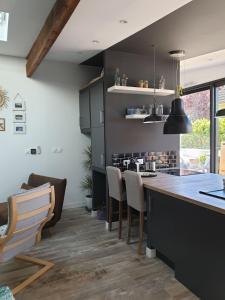a kitchen with black cabinets and a counter with chairs at L'Atelier in Auxerre
