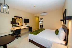 a hotel room with a bed and a desk and a computer at Eco City Hoteles in Tuxtla Gutiérrez +52 photos