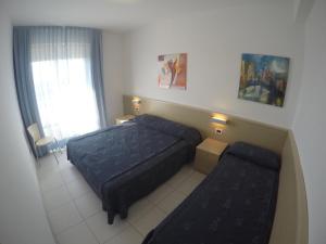 a small bedroom with a bed and a couch at Residence Zenith - Agenzia Cocal in Caorle