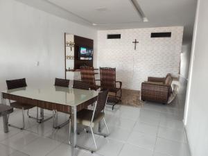 ein Esszimmer mit einem Tisch und Stühlen und einem Kreuz an einer Wand in der Unterkunft Alugo por temporada! in Campina Grande