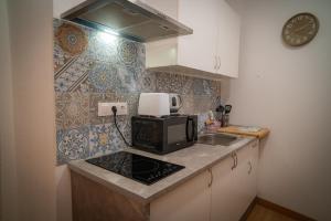 a small kitchen with a sink and a microwave at O Noso Recuncho in Palas de Rei 