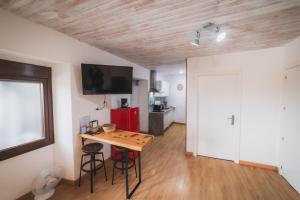 a room with a table and chairs and a television on the wall at O Noso Recuncho in Palas de Rei 