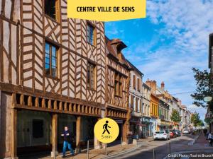 a sign in front of a building on a street at L'Atelier - By BEST KEYS - Duplex Haut de Gamme - Entièrement Climatisé - Centre-Ville - Netflix & WiFi Fibre - Machine à Café Nespresso - Check-in Autonome - Parking Gratuit à Proximité - Calme & Confort Premium in Sens