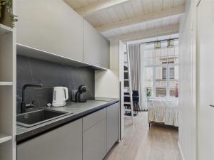 Una cocina con gabinetes blancos y un fregadero. en Chic and Compact Loft in Old Riga, en Riga