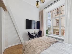 Un dormitorio con una cama y una mesa y una ventana. en Chic and Compact Loft in Old Riga, en Riga