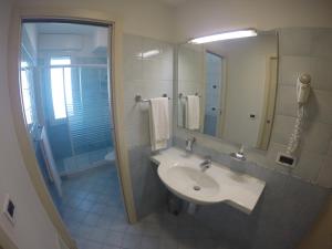 a bathroom with a sink and a shower and a mirror at Residence Zenith - Agenzia Cocal in Caorle