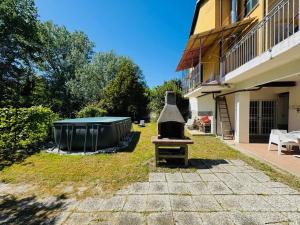 a backyard with a grill next to a building at Cottage Wisteria Piemonte in Prasco