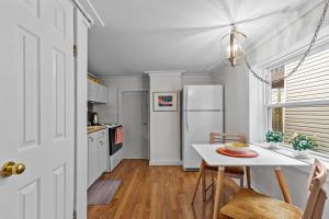 a kitchen with a table and a white refrigerator at Bond St Flat with Private Zen Garden in St. John's