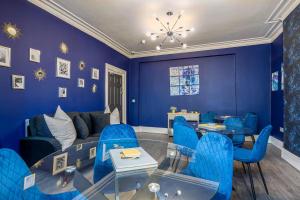 a living room with blue chairs and a glass table at Room 2, 23 Deganwy Avenue in Llandudno