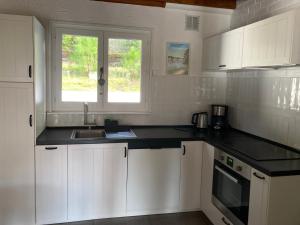 a kitchen with white cabinets and a sink and a window at Maison calme Quend-Plage Petite Californie in Quend-Plage +35 photos